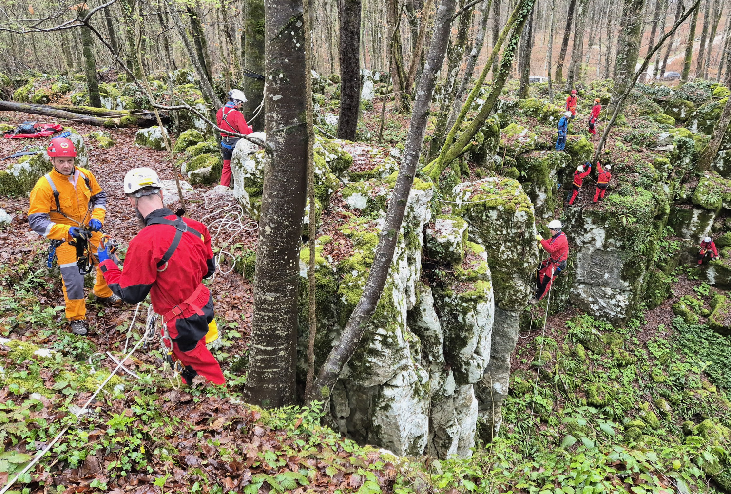 Inštruktorji in tečajniki - nekateri na robu, drugi v steni.