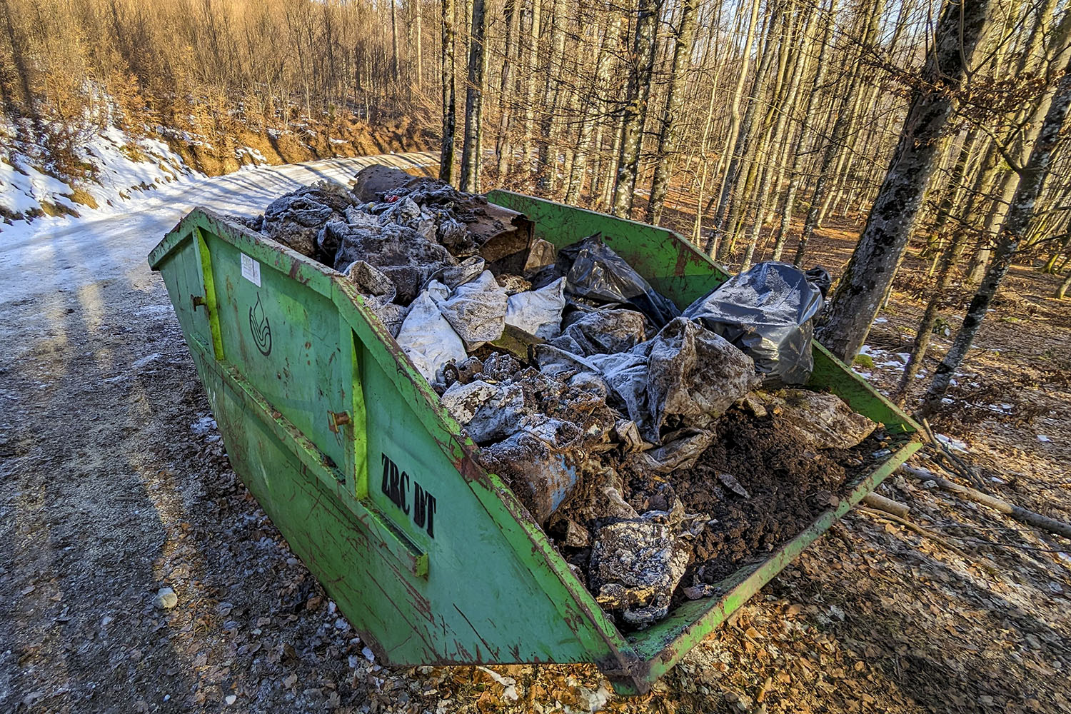 Poln zabojnik raznovrstnih odpadkov iz Brezna v ovinku nad Podhosto. Foto Marko Pršina