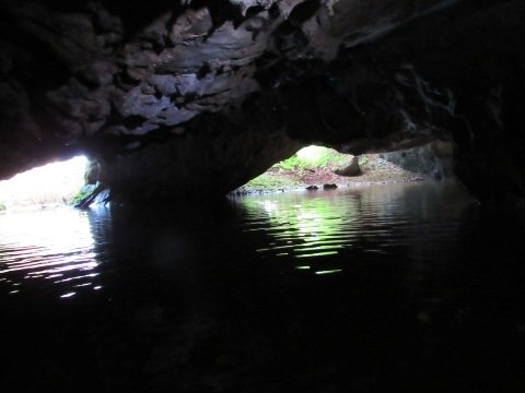 Pogled z jezera na oba velika vhoda. Skozi levega priteče v jamo voda Rudniškega potoka. Foto Borivoj Ladišić.