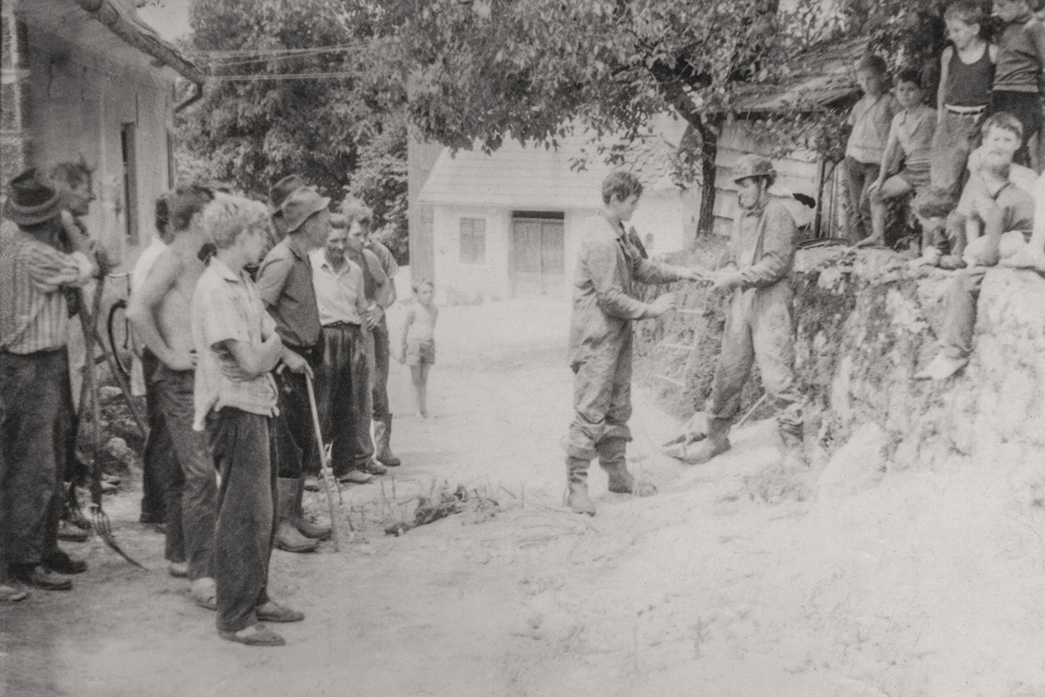 Zanimanje Gabrčanov ob prvih spustih v jamo sredi vasi (okoli 1965). Jamar s čelado je Lojze Medle